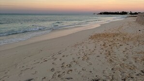 A beach with footprints and a calm sea under a clear sky. - Sun Fun Resort (Nassau)