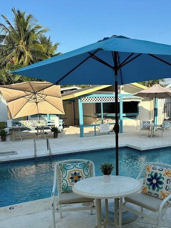 Una piscina al aire libre, sillones reclinables de piscina