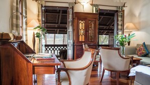 Une pièce traditionnelle en bois, comprenant un bureau, deux chaises, une armoire et un canapé.