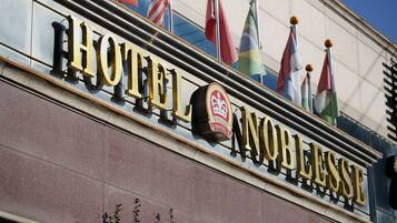 A hotel sign with flags and a logo.