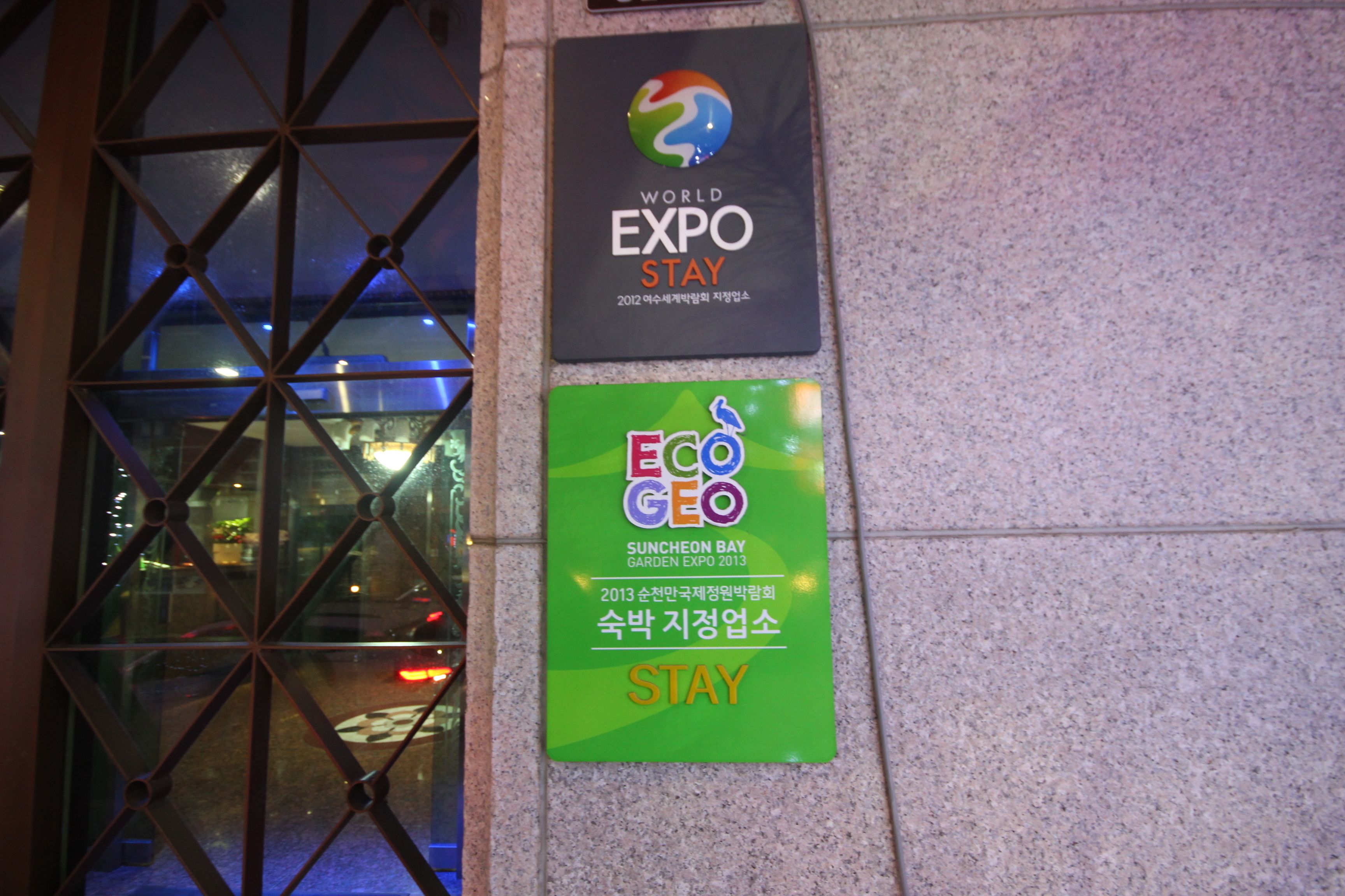 Two signs on a wall: one for the World Expo Stay and another for the Eco Geo Suncheon Bay Garden Expo 2013.