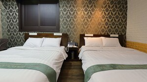 A hotel room with two beds, a wooden headboard, a telephone, and a trash bin. - Suncheon Noblesse Hotel (Suncheon)
