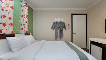 Una habitación de hotel con cama, escritorio y armario.