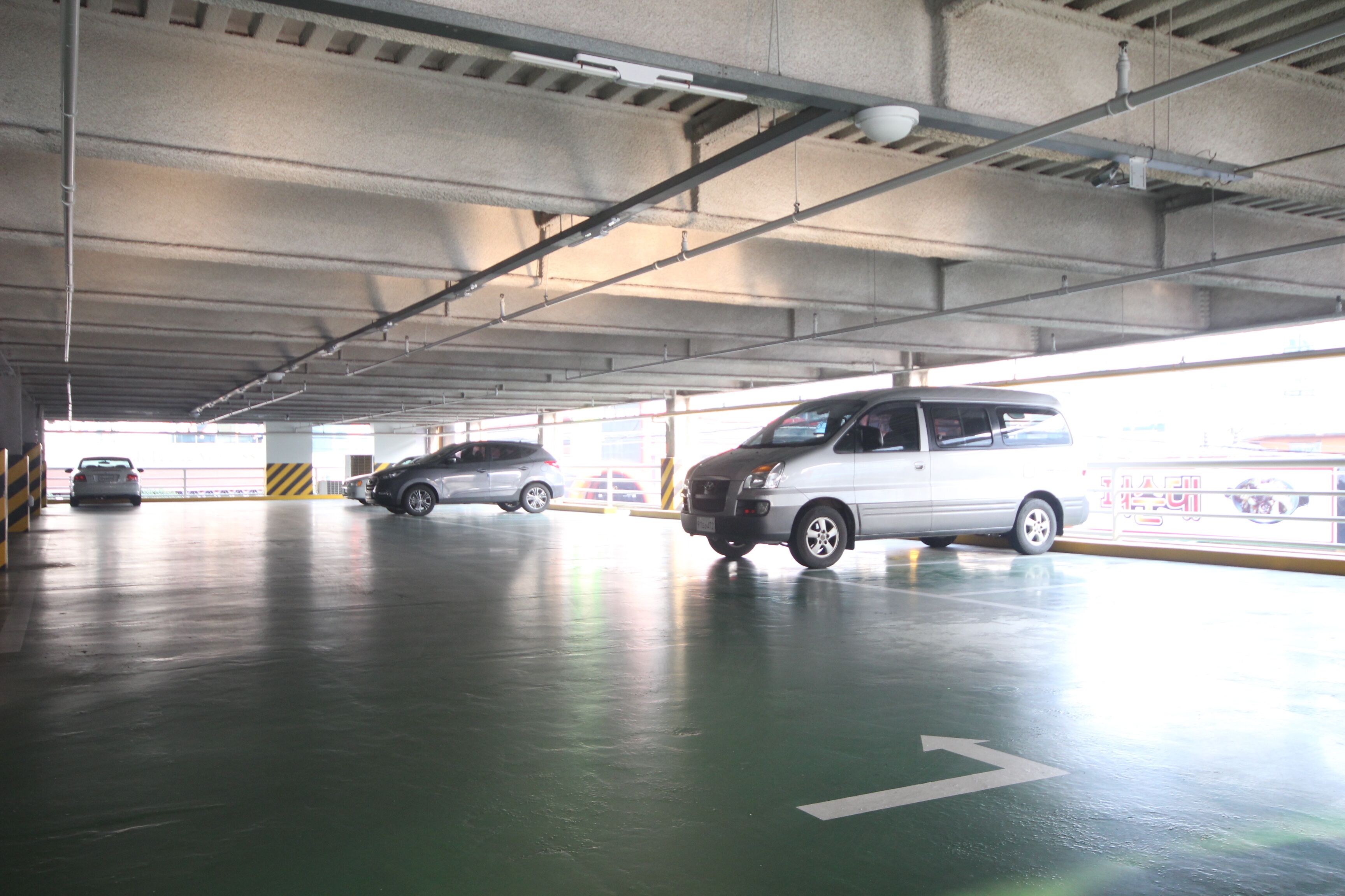 Un estacionamiento con varios coches aparcados en sus espacios designados.