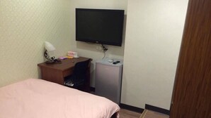 A small hotel room with a bed, a desk, a television, and a mini-fridge. - Come Inn Taipei 3 (Taipei)