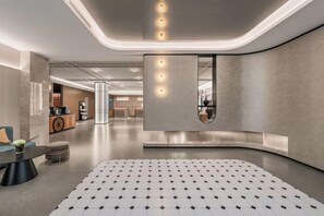A modern interior with a central seating area, a kitchen in the background, and a curved wall feature. - Homeinn Plus Hotel (Shanghai Zhangjiang Guanglan Road Subway Station) (Shanghai)