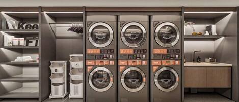 Un cuarto de lavandería con varias lavadoras, una máquina de café y un lavabo.