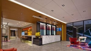 A modern lobby with a reception desk, seating area, and a bar. - Guangzhou TianHe Hotel (Panyu Shiqiao Subway Station) (Guangzhou)