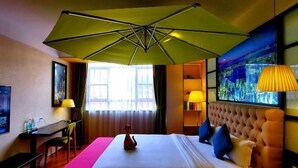 A hotel room with a bed, a desk, a chair, a lamp, a painting, and a window. - Guangzhou TianHe Hotel (Panyu Shiqiao Subway Station) (Guangzhou)