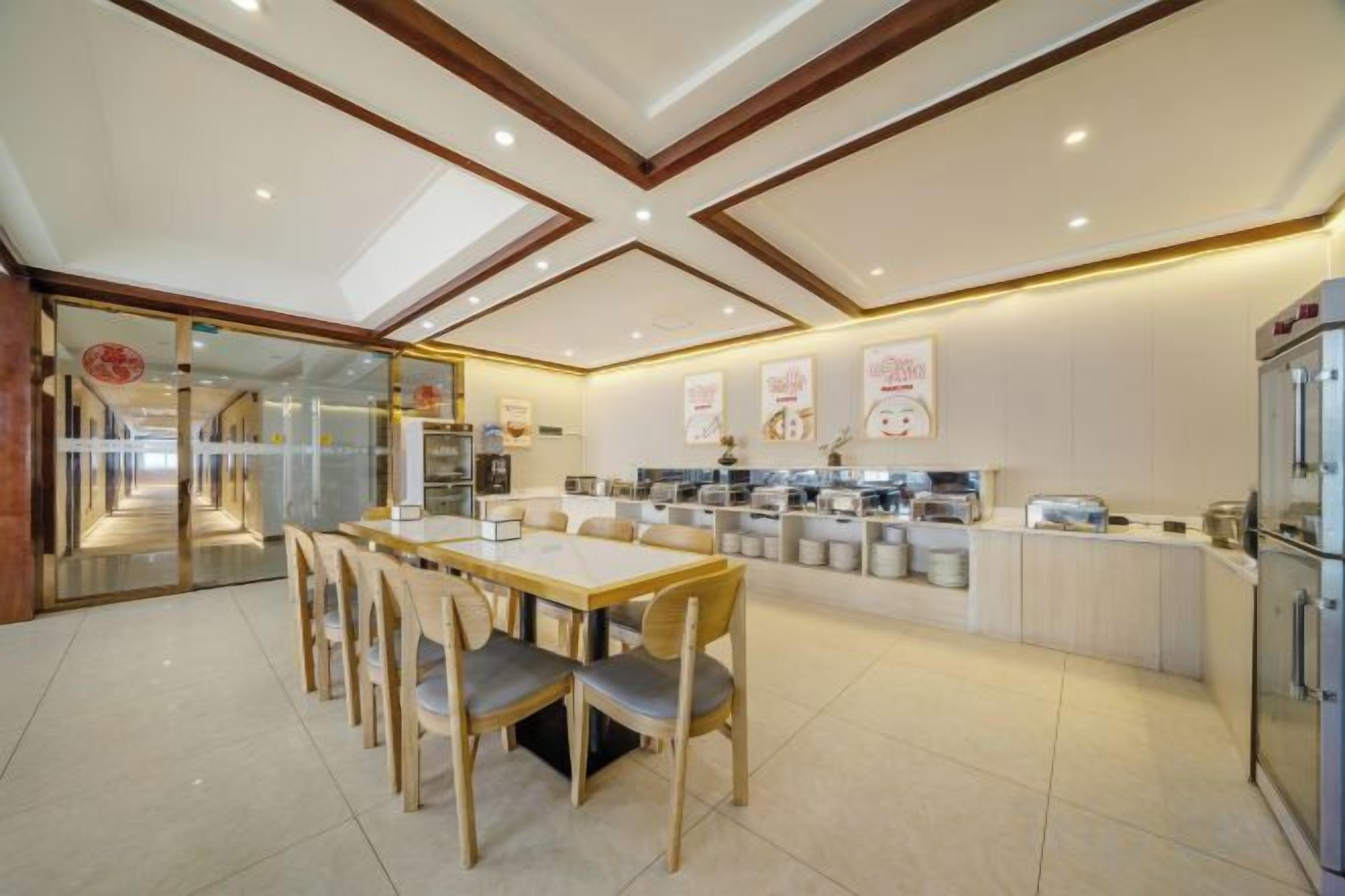 A modern kitchen with a dining area, featuring a central island, built-in appliances, and a glass partition.