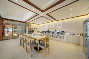 Cocina moderna con comedor, que incluye una isla central, electrodomésticos integrados y un separador de vidrio.