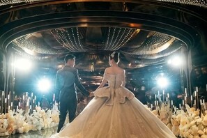 A couple walking through a venue with a circular ceiling and bright lights. - Huaxi Hotel Dujiangyan (Chengdu)