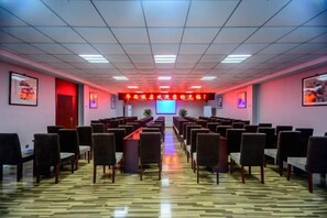 A conference room with rows of chairs, a long table, and a projection screen. - Huaxi Hotel Dujiangyan (Chengdu)