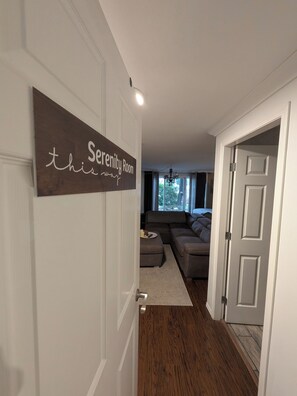 A hallway leading to a living area with a sign reading 'Serenity Room.'
