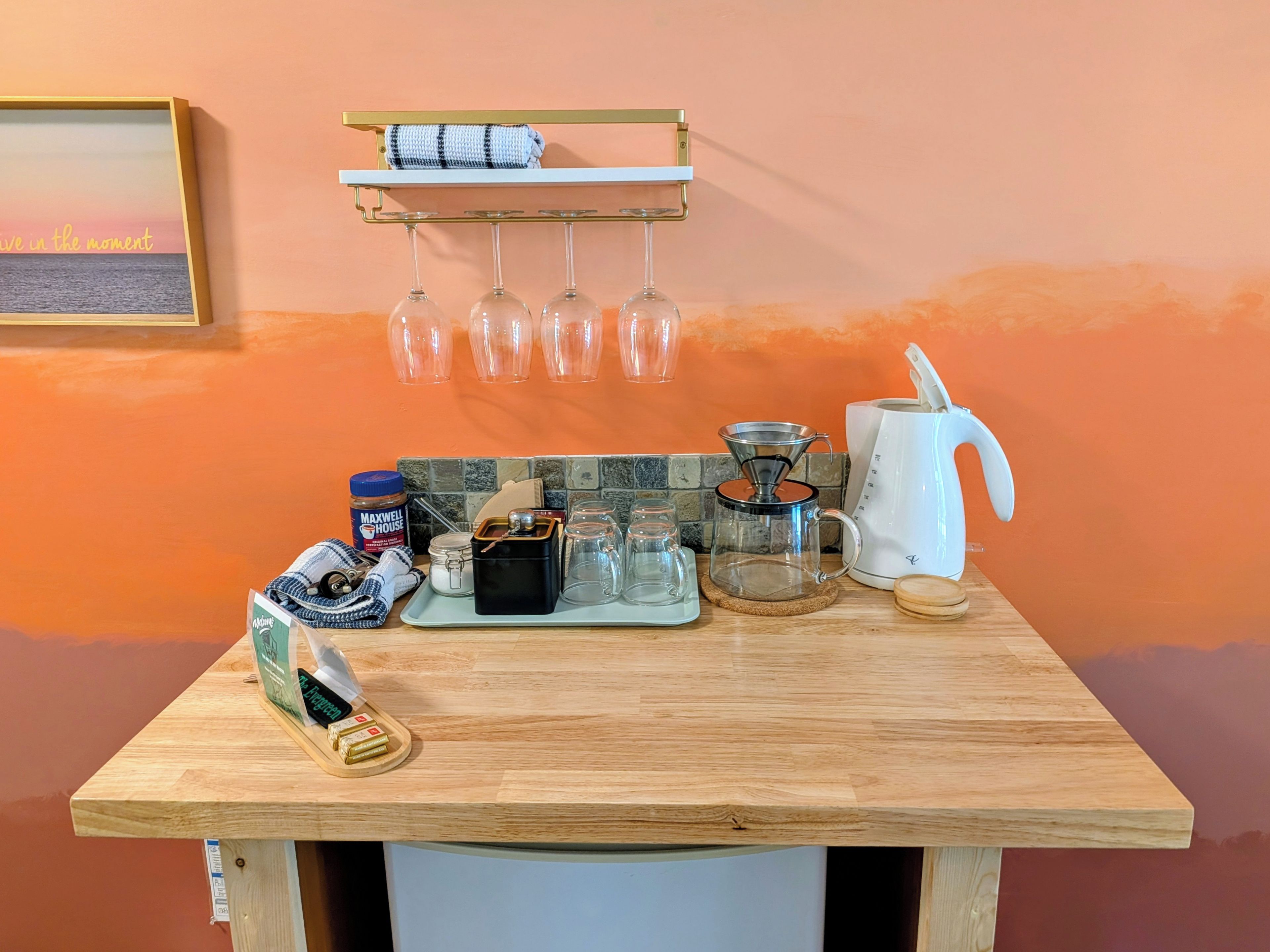 Un plan de travail de cuisine avec une machine à café, une bouilloire et divers ustensiles de cuisine.