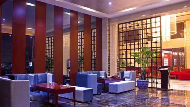 A modern lobby with seating areas, a reception desk, and a large window with a view. - Jing Lin (Beijing)