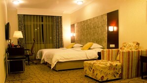 A hotel room with a bed, a chair, a desk, and a lamp. - Jing Lin (Beijing)
