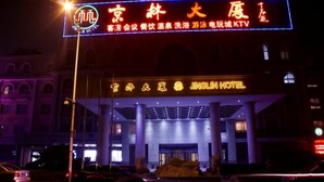 A hotel with a prominent neon sign displaying its name and services. - Jing Lin (Beijing)