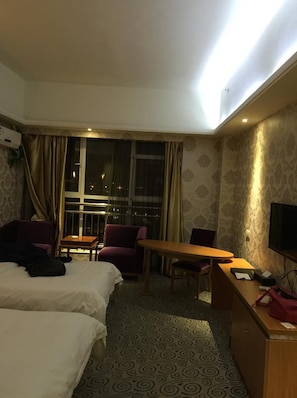 A hotel room with two beds, a desk, a chair, a TV, and a window with curtains. - Youhao Qiancheng Boutique Hotel (Nanjing)