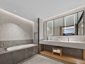 A modern bathroom with a large mirror, a bathtub, and a vanity with a wooden shelf. - Hilton Garden Inn Huangshan Scenic Area South Gate (Huangshan)