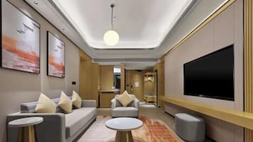 Suite Deluxe, 1 cama de matrimonio grande | Zona de estar | Una televisión