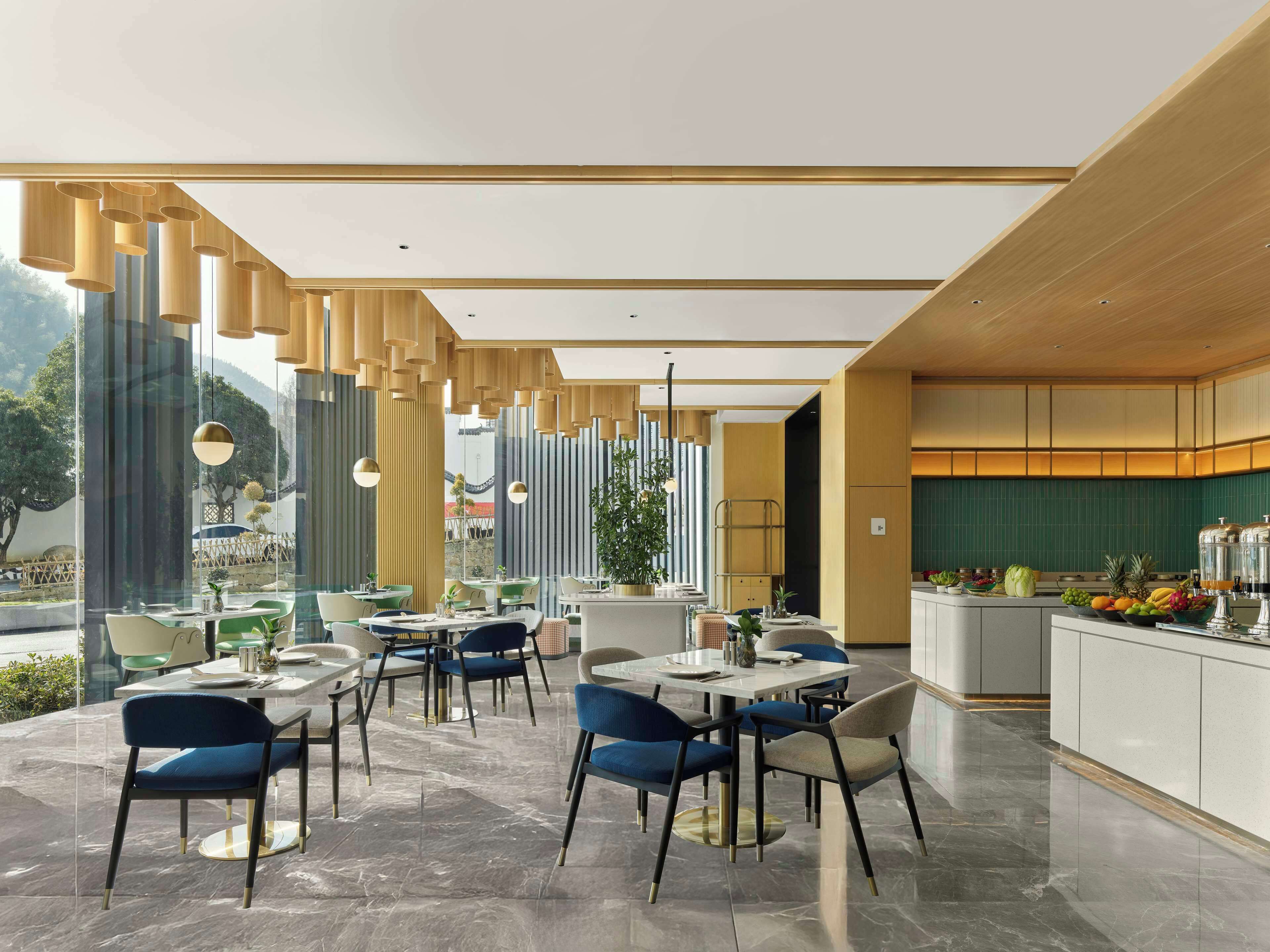 Un restaurant moderne doté d’un long comptoir, de nombreuses tables et de chaises.
