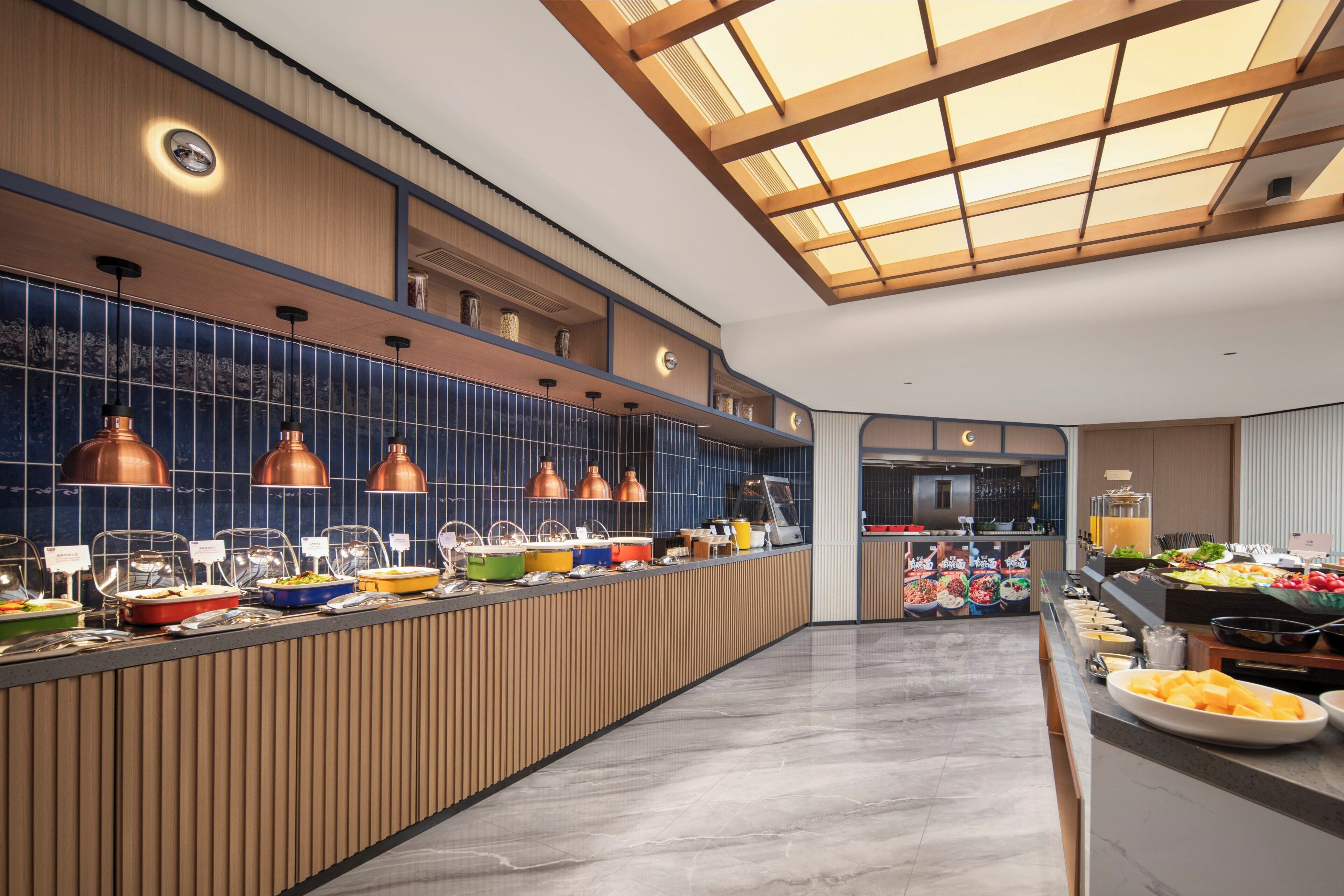 Un buffet moderne, proposant une grande variété de plats, avec un comptoir en bois et un éclairage suspendu.