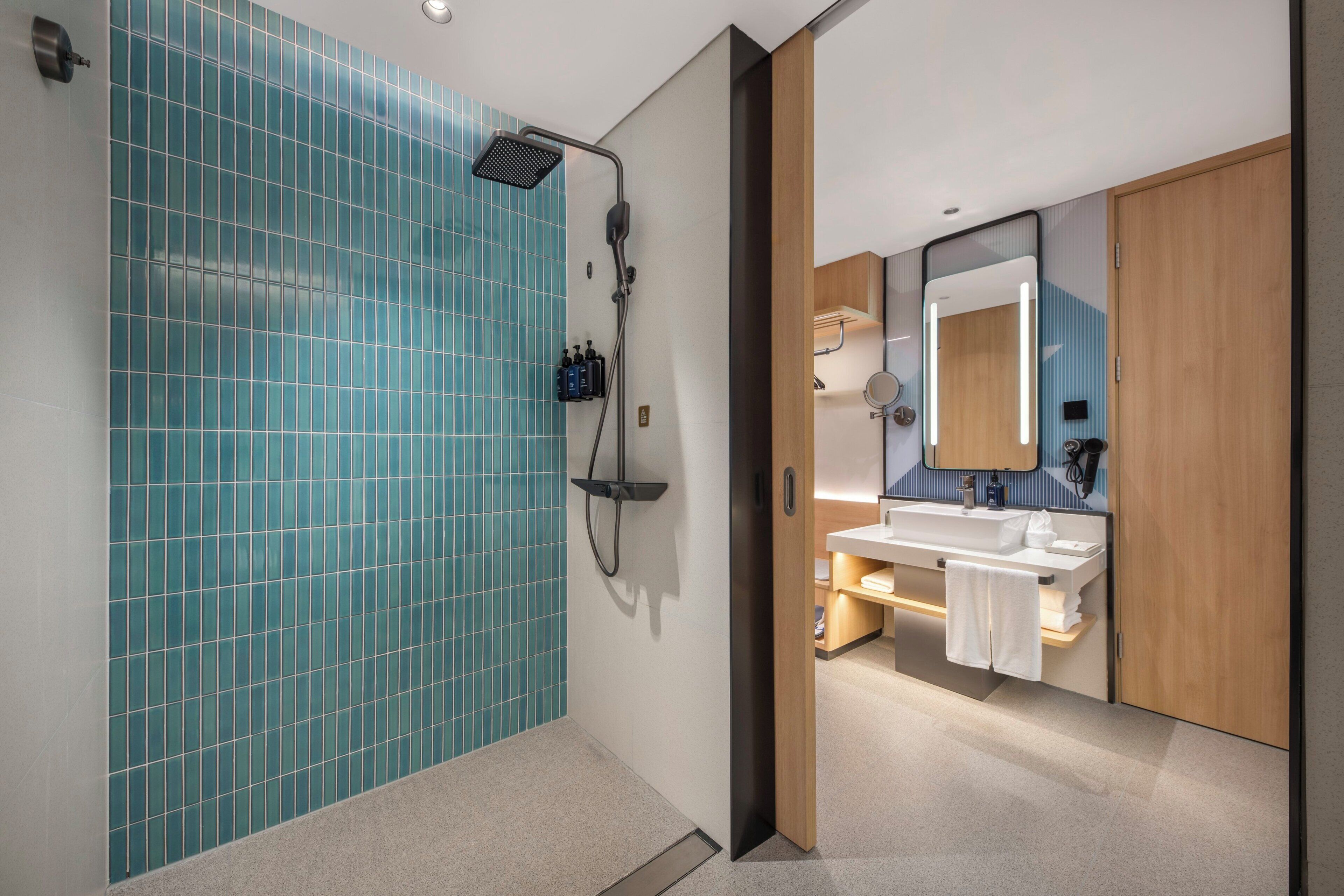 A modern bathroom with a shower, a sink, and a mirror.