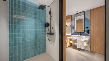 A modern bathroom with a shower, a sink, and a mirror.