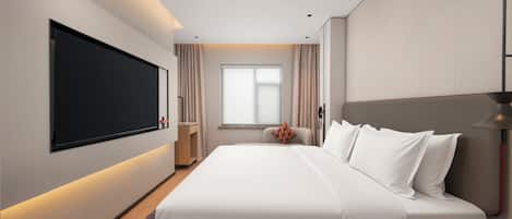 Una habitación de hotel moderna con una cama grande, un televisor de pantalla plana, una mesita de noche y un ventanal con cortinas.