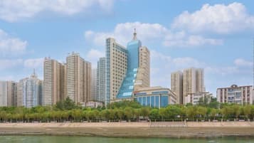 A city skyline with high-rise buildings, a waterfront, and a park with trees.