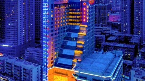 Un immeuble de grande hauteur, doté de nombreux étages, qui se distingue par un coin particulièrement visible, agrémenté d’une enseigne lumineuse et par un style architectural original.