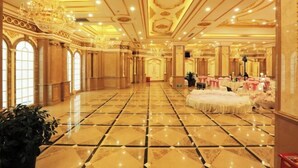 Un vaste hall doté d’un sol en marbre poli, de lustres somptueux et de tables dressées pour un événement officiel.