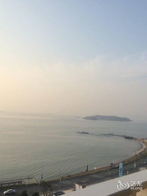 A coastal view with a clear sky, a calm sea, and a distant island. - Ramada by Wyndham Huizhou Xunliao Bay (Huizhou)
