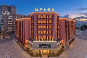 A hotel with a modern design, featuring a prominent entrance and multiple floors. - Jinhua Hotel (Honghe)