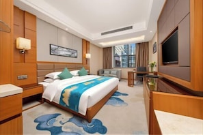 Une chambre d’hôtel avec un grand lit, un bureau, une télévision et une vue sur la ville.