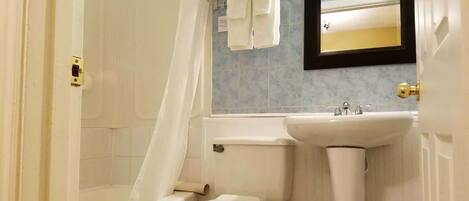 A bathroom with a toilet, sink, and shower.