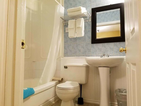 A bathroom with a toilet, sink, and shower.
