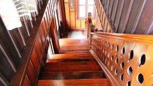 A wooden staircase with a handrail and a patterned wall. - Villa Senesouk (Luang Prabang)