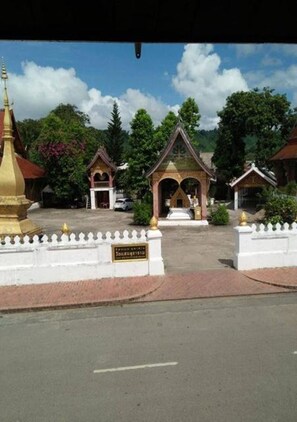 A temple complex with a central shrine, smaller structures, and a white fence.
