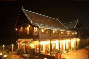 A traditional wooden building with multiple balconies and a covered patio area. - Villa Senesouk (Luang Prabang)