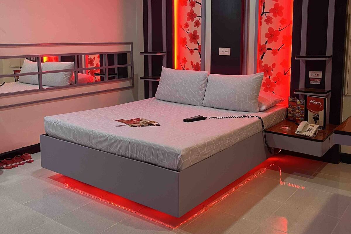 A modern bedroom with a bed, bedside tables, and a nightstand.