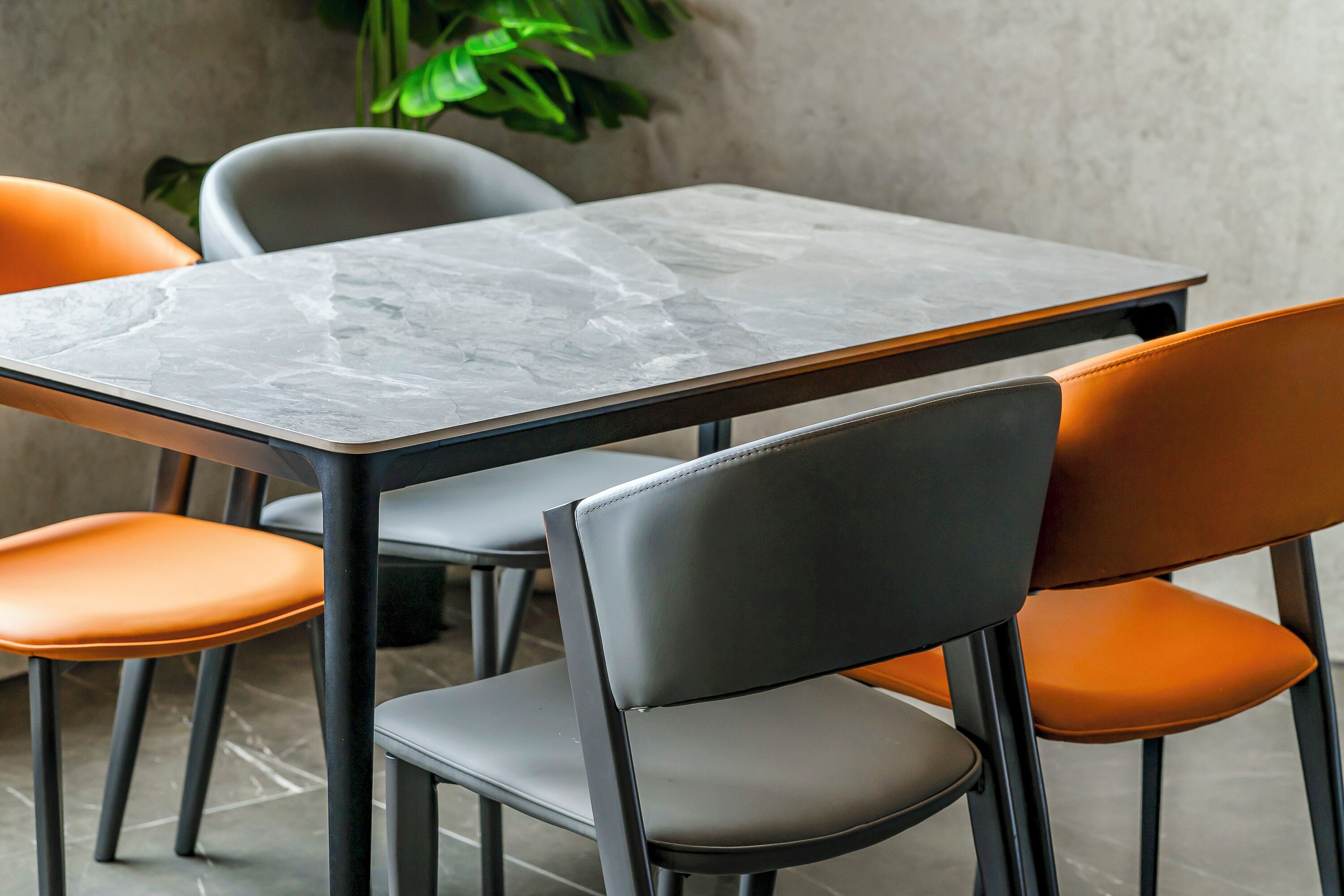 Un espace repas avec une table et des chaises en marbre.