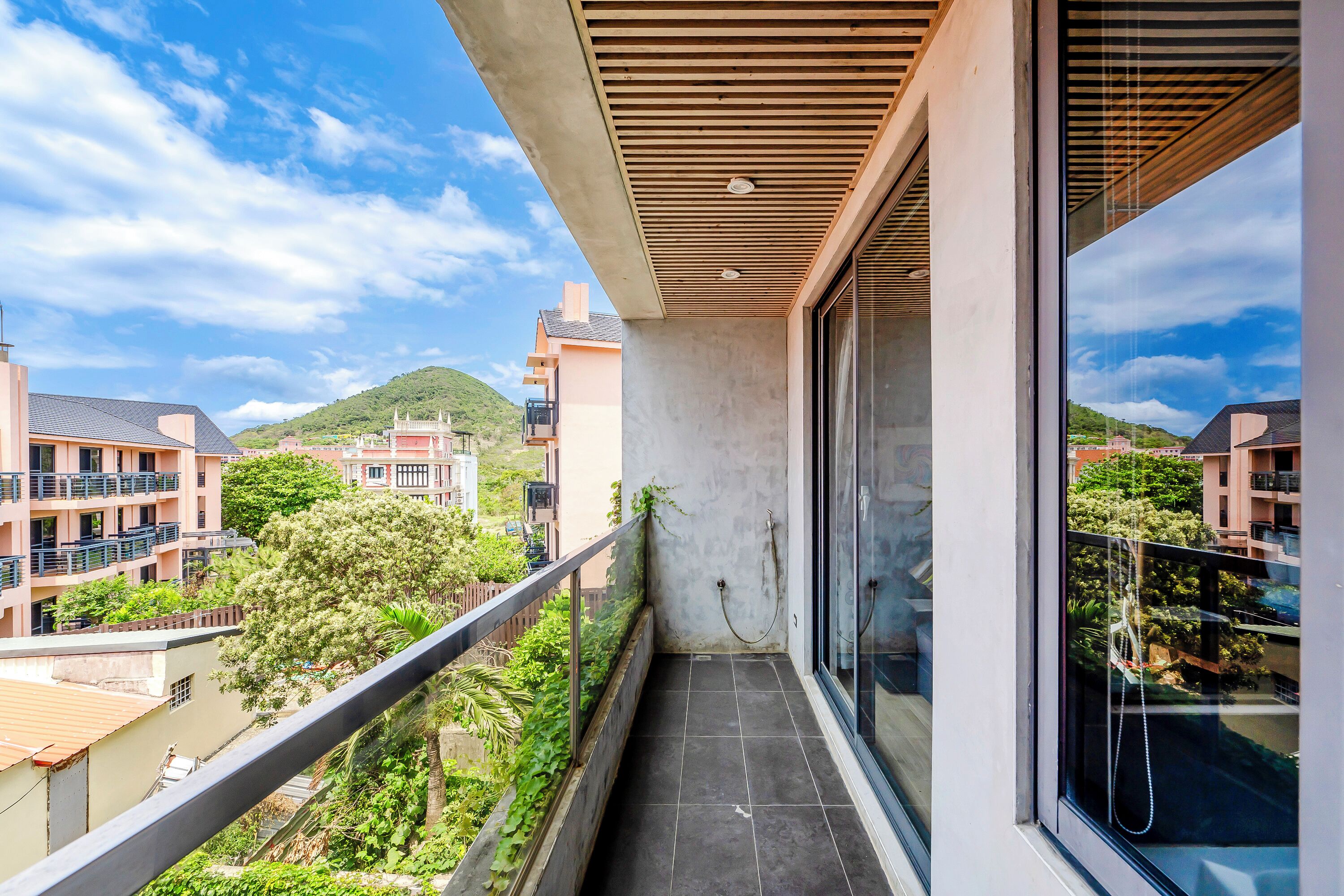 Un balcón con vista a edificios vecinos y áreas verdes.