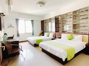 A hotel room with two beds, a large shoe display, a desk, and a window with curtains. - Warner Leisure Hotel (Hengchun)