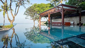 Una piscina al aire libre, sombrillas, sillones reclinables de piscina
