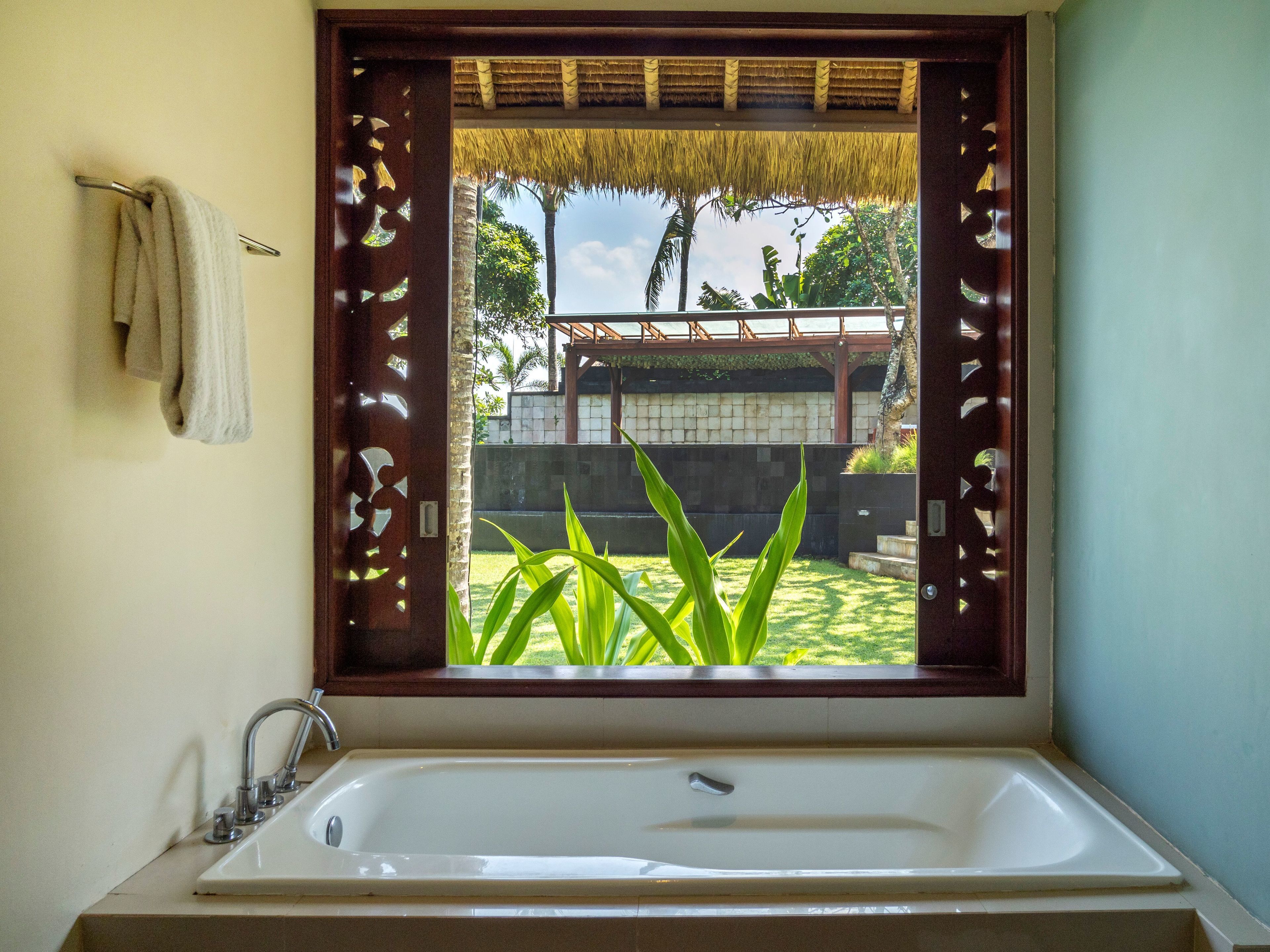 A bathroom with a large window, a sink, and a towel rack.