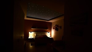 A dimly lit room with a bed, bedside lamps, and a starry ceiling. - B&B Dimora dell'Etna (Milo)