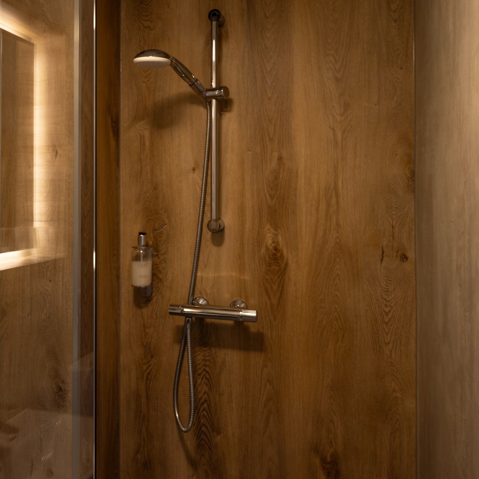 A wooden door with a showerhead and hose.