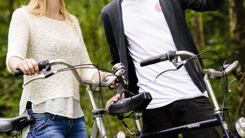 Dos personas junto a bicicletas en un área boscosa.